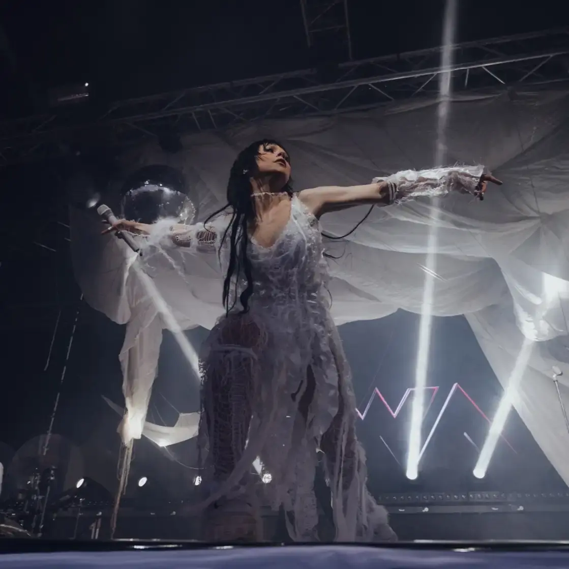 Performance by the group IOWA: vocalist on stage with the group's trademark logo